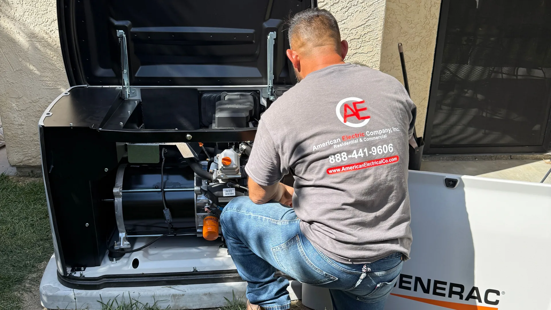 An American Electric Co technician servicing the open engine bay of a Generac standby generator